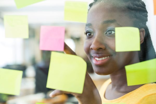 Female graphic designer looking at sticky notes in office